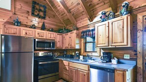 Una cocina con armarios de madera, electrodomésticos de acero inoxidable y objetos decorativos sobre las encimeras.