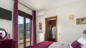 Une chambre à coucher avec un lit, une chaise, une armoire et un balcon offrant une vue.