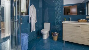 Une salle de bain moderne avec une douche à parois de verre, des toilettes blanches et un meuble-lavabo en bois avec un miroir.