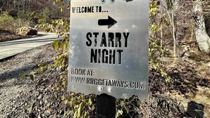 Une pancarte d’accueil pour « Starry Night », avec une flèche indiquant la direction et l’adresse web du site de réservation.