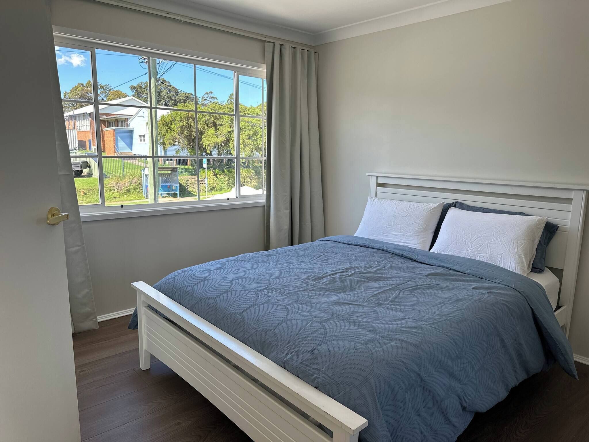 Un dormitorio con cama, ventana y vista al exterior.