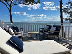 A deck with outdoor seating, a view of the sea, and a clear sky. - Dreamy Lake Retreat & Sunsets (Lake Heights)