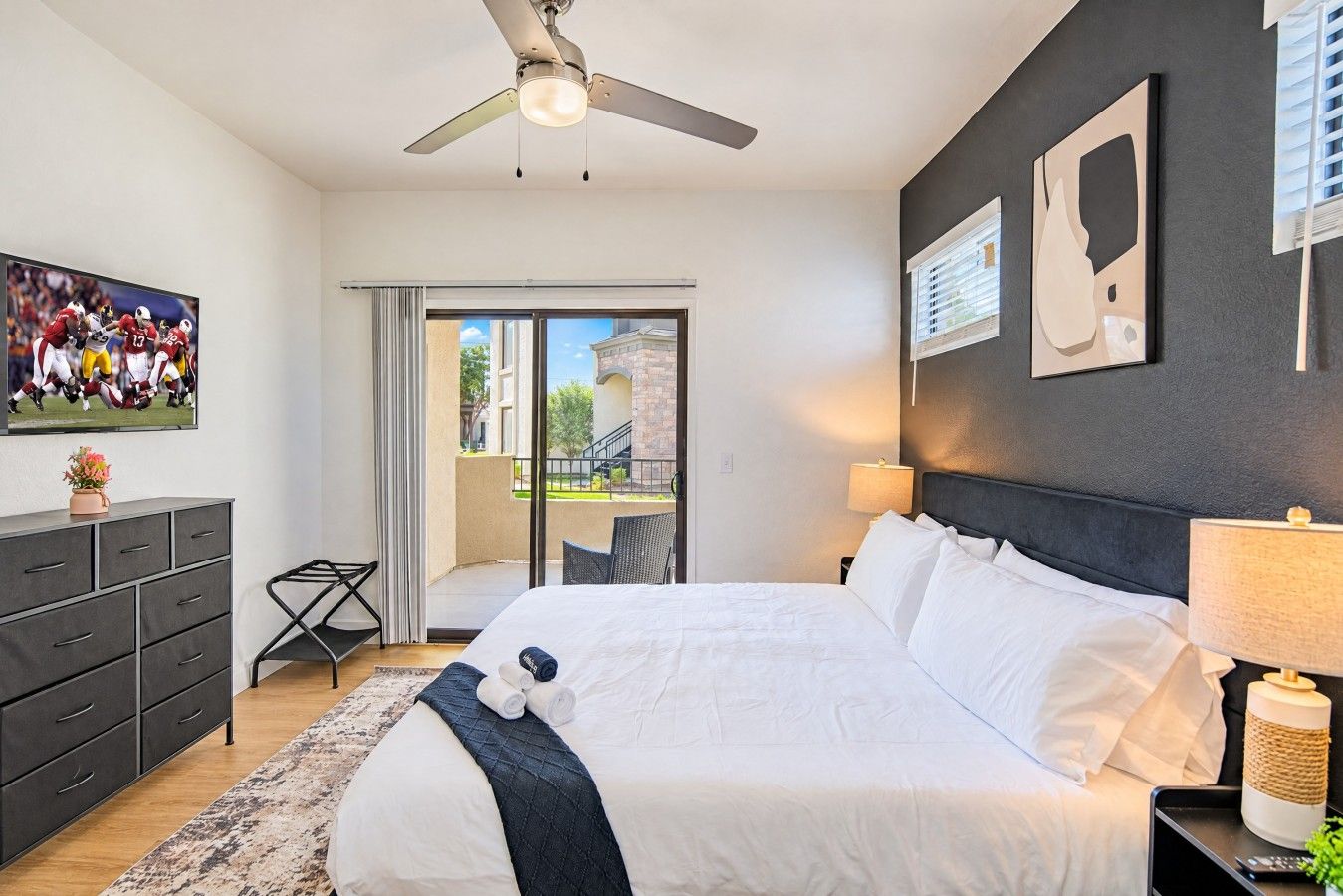 Une chambre d’hôtel avec un lit, un bureau, une chaise, une télévision et un balcon avec vue.