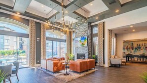 A spacious lobby with a fireplace, comfortable seating, and large windows offering views of the city.