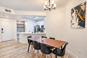 A modern kitchen with white cabinets, a stainless steel refrigerator, and a microwave. - Near Attractions |Balcony, Pool, Gym, Parking, W/D (Glendale)