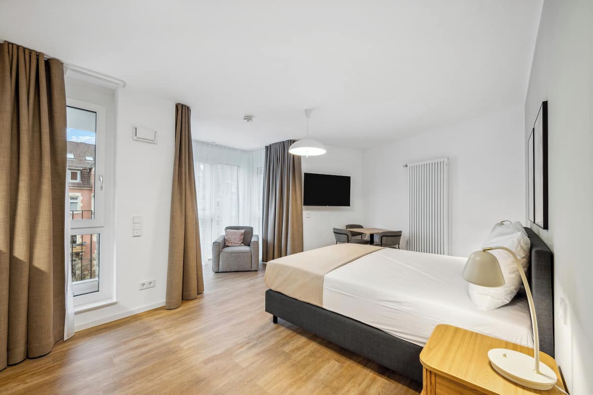 Une chambre d’hôtel moderne, dotée d’un grand lit, d’un bureau et d’une chaise.