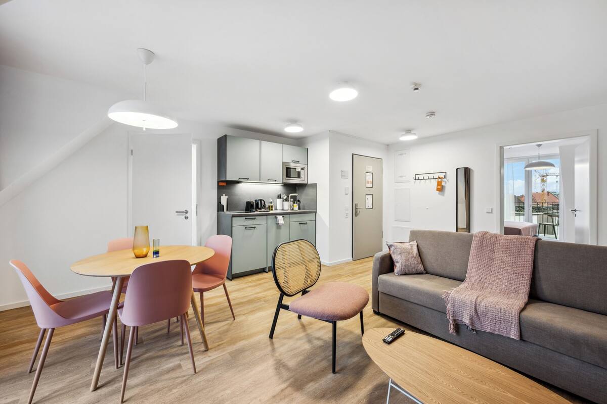 Un appartement moderne comprenant un coin repas, une cuisine et un salon.