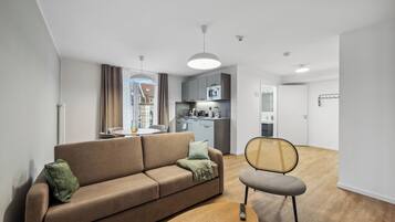 A modern living room with a sofa, a chair, and a dining area.