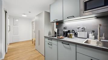 Eine moderne Küche mit grauen Schränken, Edelstahlgeräten und Holzboden.