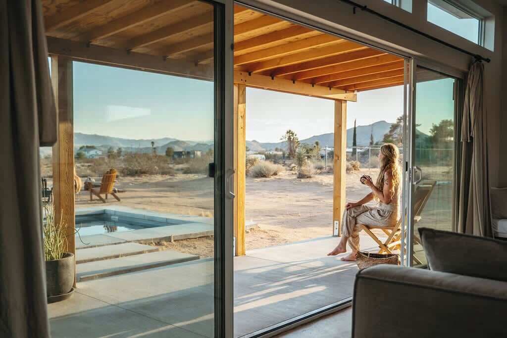 A modern interior with large sliding glass doors leading to an outdoor patio area.