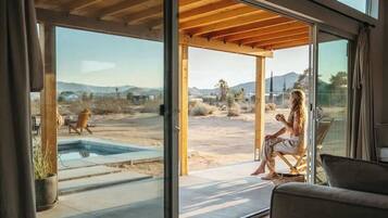 A modern interior with large sliding glass doors leading to an outdoor patio area.