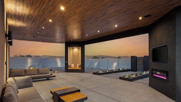 A modern living room with a large sofa, a coffee table, and a fireplace. - Free Bird • Pool, Spa, Pickleball, Outdoor Lvg Rm! (Joshua Tree)