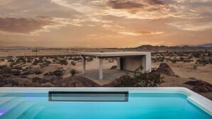 A desert landscape with a modern pool and a small structure. - Prism • Modern Luxury in Boulders, Pool & Hot Tub (Joshua Tree)