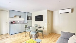 Een compacte woonruimte met kitchenette, eethoek en een zithoek.