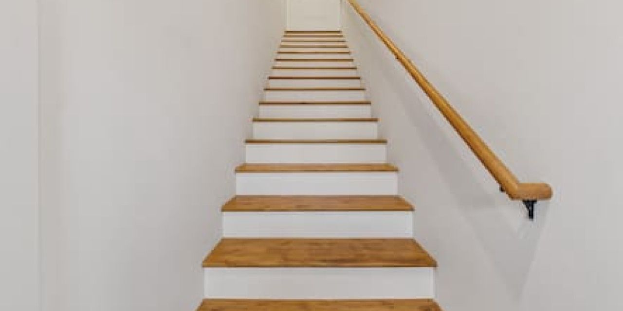 A staircase with wooden steps and a wooden handrail.