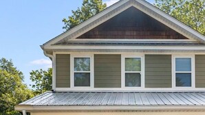 A two-story house with a covered porch, a garage, and a well-maintained lawn.