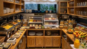 Een buffetopstelling met diverse gerechten, drinkglazen en een koffiehoek.