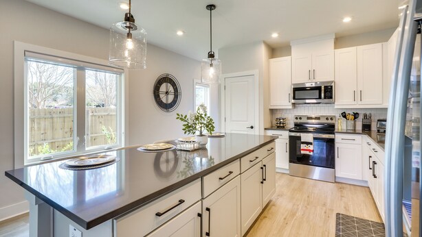 A modern kitchen with a large island, stainless steel appliances, and white cabinetry. - 2 Mi to Duke & 3 Mi to Downtown: Durham Townhome (Durham)