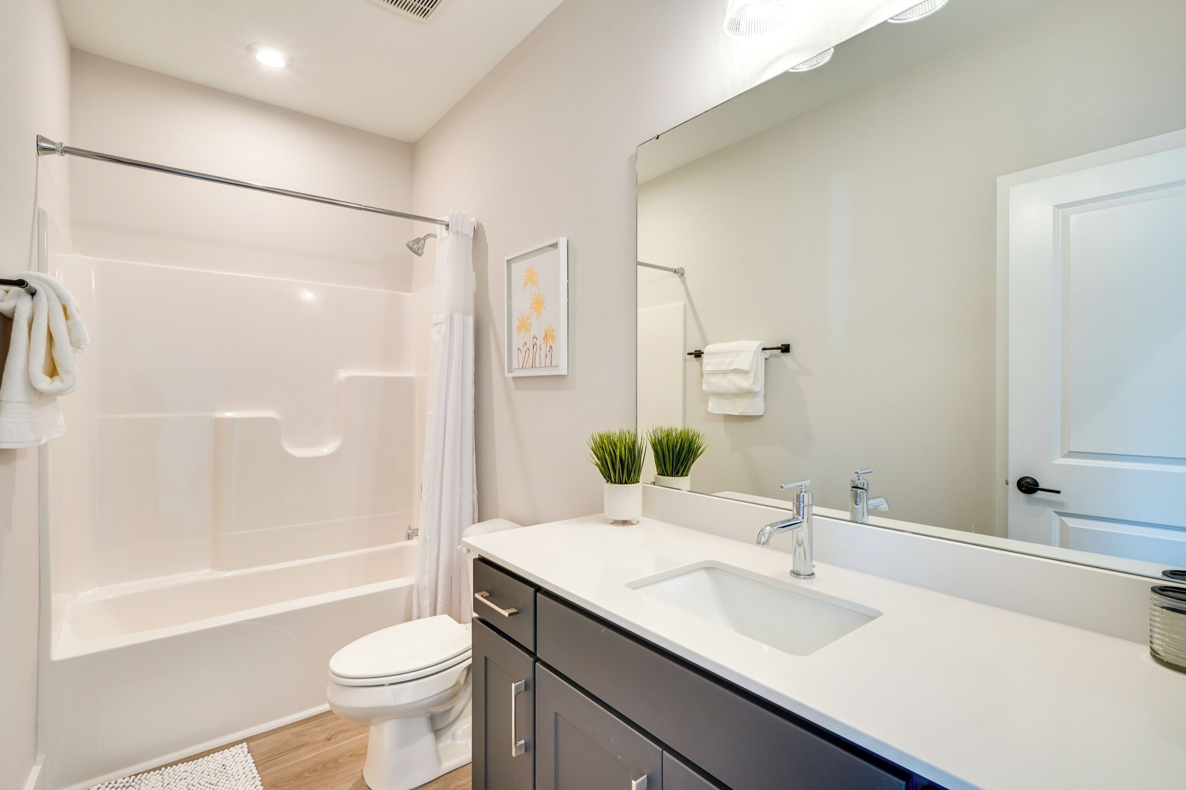 A modern bathroom with a bathtub, toilet, and sink.