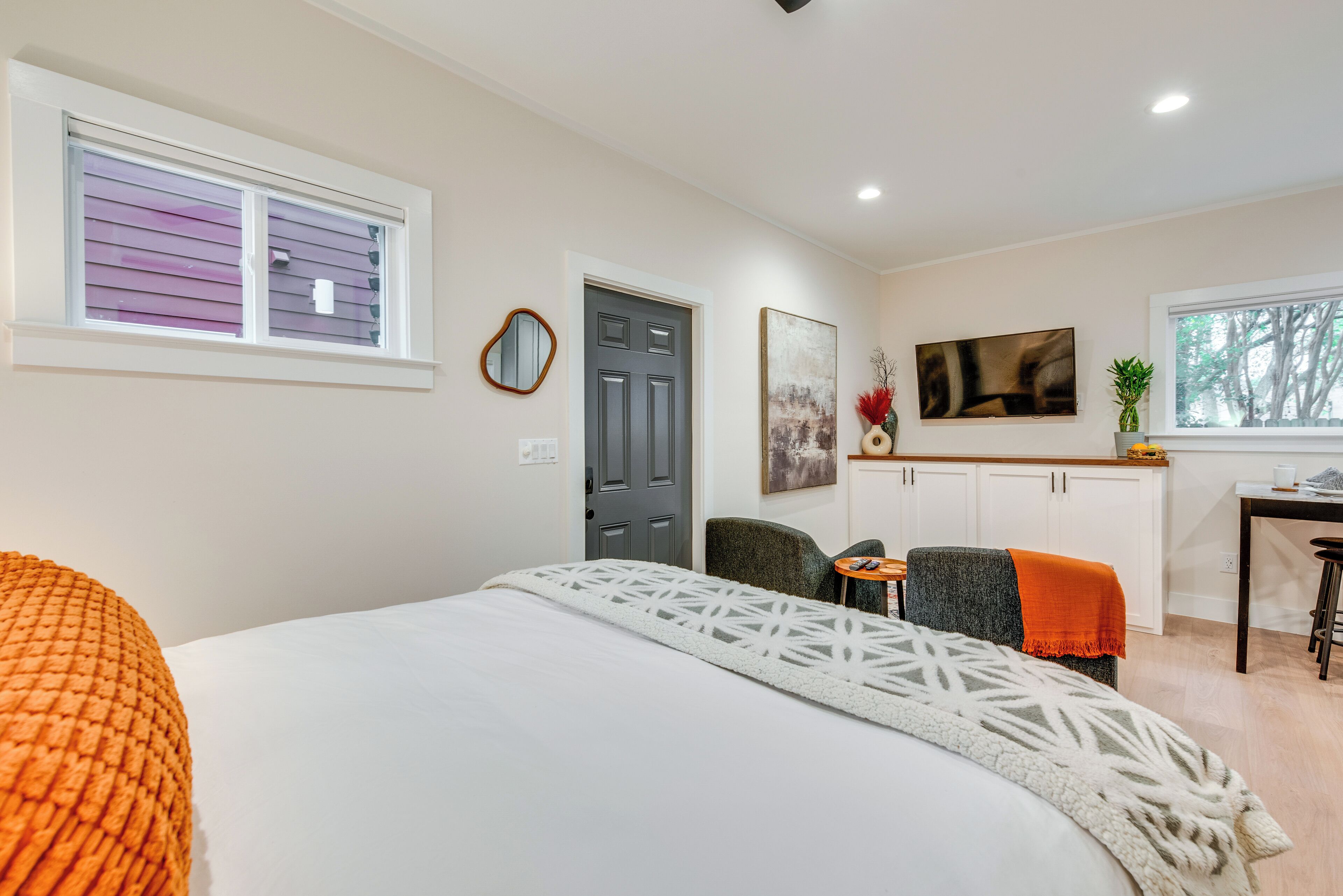 Une chambre à coucher avec un lit, un bureau, une chaise et une porte.