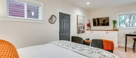 Une chambre à coucher avec un lit, un bureau, une chaise et une porte.