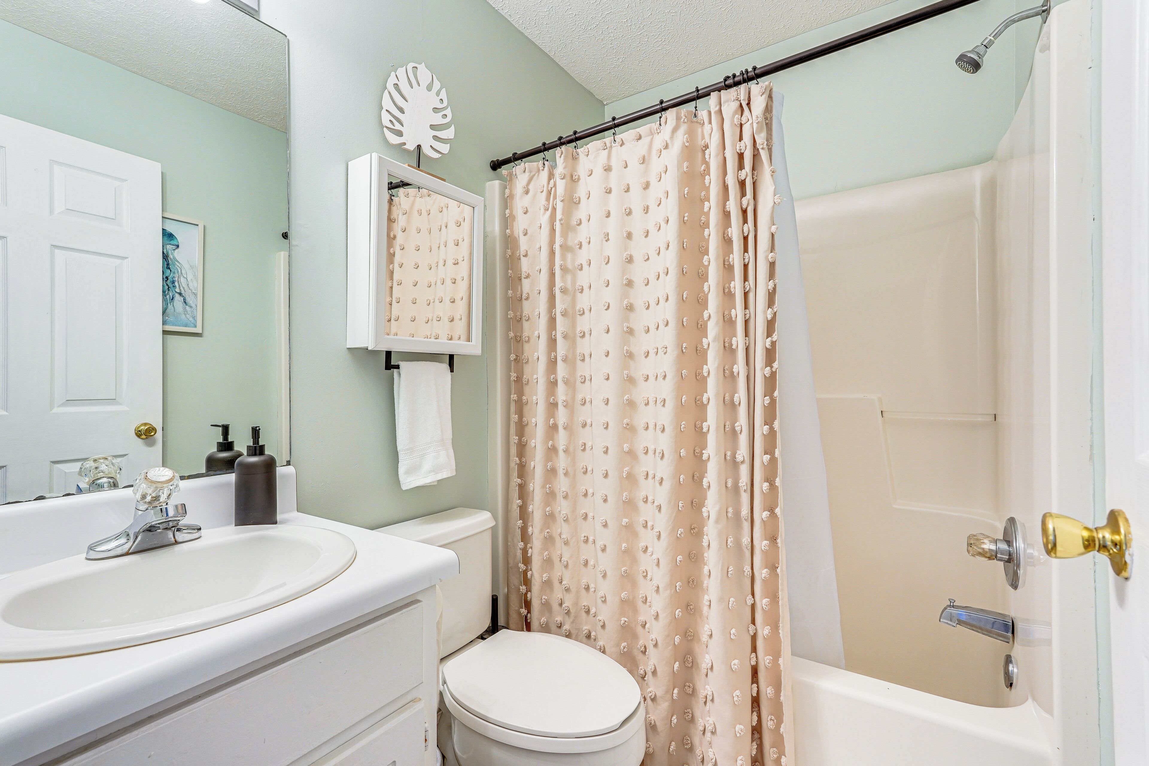 A bathroom with a sink, toilet, and shower.