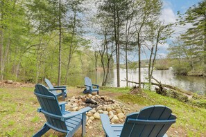 A lakeside setting with Adirondack chairs arranged around a campfire. - < 3 Mi to Uconn: Peaceful Home on Pine Lake (Coventry)