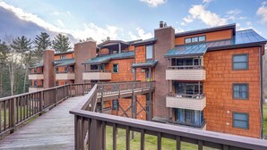 Un edificio de varios pisos con terraza de madera y balcones.