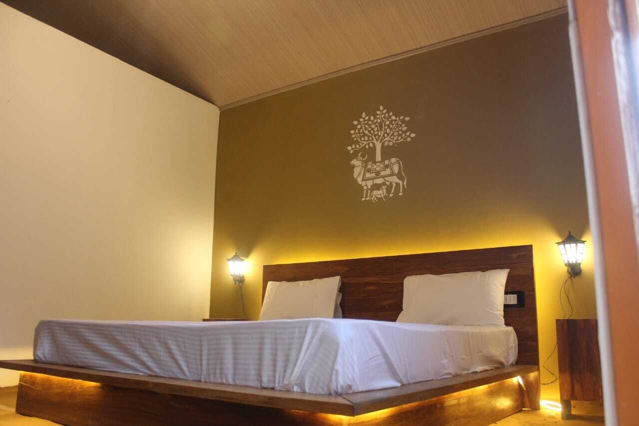 A bed with a wooden frame and headboard, two bedside lamps, and a wall decoration of a tree with a horse.