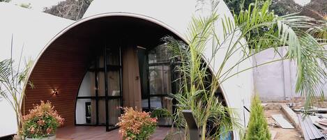 A modern, dome-shaped building with a wooden interior and large windows.