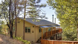 A two-story house with a wooden deck and stairs leading to a balcony. - Ski, Hike & Fish: Mtn-view Gem w/ Deck in Tuolumne (Tuolumne)