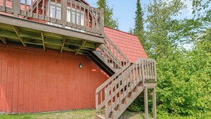 A red wooden building with a wooden staircase leading to a balcony. - Waterfront Long Lake Retreat: Great for Families! (Sinclair)