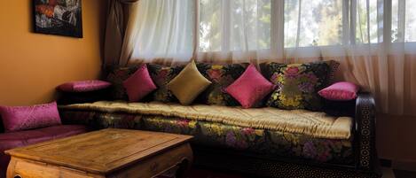 Un salon chaleureux avec un canapé, une table basse et un tapis à motifs.