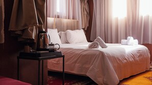 A hotel room with a bed, a bedside table with a coffee maker, and a window with curtains. - Couleurs Berbères (Lalla Takarkoust)