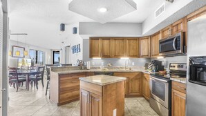 Une cuisine moderne avec des meubles en bois, des appareils en acier inoxydable et un grand îlot central.