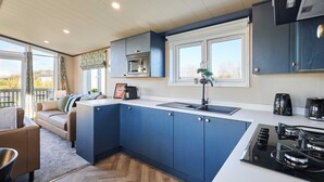 Eine moderne Küche mit blauen Schränken, einer weißen Arbeitsplatte und einem eingebauten Herd.
