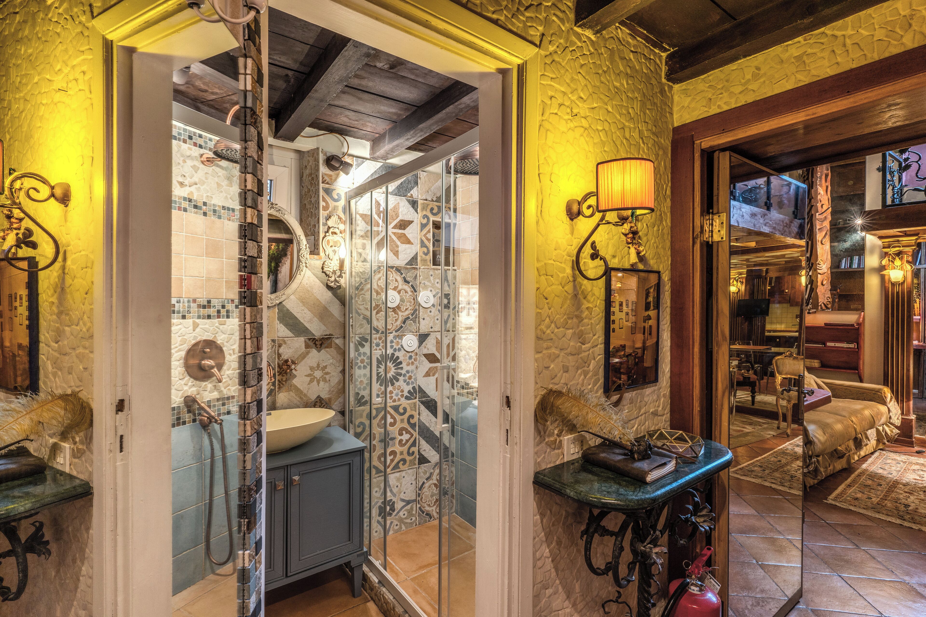 A bathroom with a glass shower enclosure, a sink, and a mirror.
