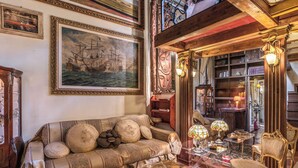 A vintage-style living room with a sofa, armchairs, a coffee table, and a bookshelf. - Campo de Fiori - Eleanor Suite luxury & history 1BD 1BH (Roma)
