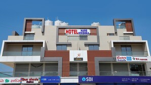 Ett hotell som heter ”Hotel Hare Krishna” med en modern design, kännetecknat av en tydlig skylt, en logotyp och ett kontor tillhörande SBI-banken.