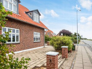 A residential house with a red-tiled roof, brick walls, and a paved driveway. - 2 Person Holiday Home in Ringkobing (Ringkobing)
