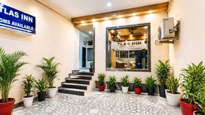 A hotel entrance with a sign indicating rooms are available, a reception desk, and potted plants along the walkway. -  Atlas Inn Near to IGI Airport (Firoj)