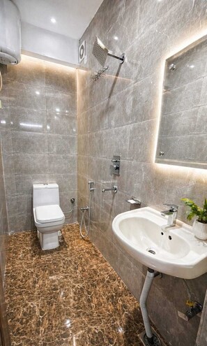 A modern bathroom with a toilet, shower, and sink.