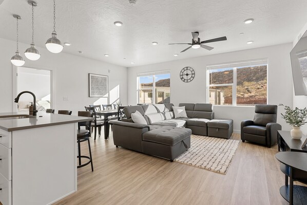 A spacious living area with a large L-shaped sectional sofa, a dining table with chairs, and a kitchen area with a bar. - Cliff Side Retreat 2 Bedroom Condo (Washington)
