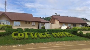 Un bâtiment sur lequel on peut lire l’inscription « HÔTEL-CHALET » et qui est surmonté d’une antenne parabolique.
