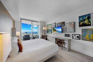Una habitación de hotel moderna con una cama grande, un escritorio y vistas a la ciudad.
