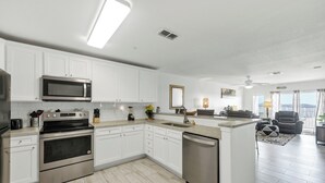 A modern kitchen with white cabinets, stainless steel appliances, and a dishwasher. - Spacious beachfront condo with community pool, located on the first floor of the (Port Aransas)
