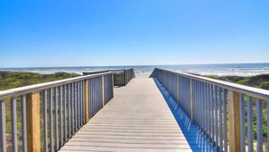 A wooden boardwalk leading to the beach with railings on both sides. - Spacious beachfront condo with community pool, located on the first floor of the (Port Aransas)