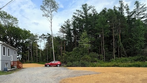 A gravel driveway leading to a house with a red car parked in front. - 2Bed1 bath Near Ithaca &Cornell lower unit (Locke)