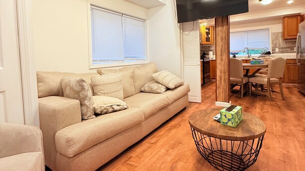 A living room with a beige sofa, a coffee table, and a ceiling fan. - 2Bed1 bath Near Ithaca &Cornell lower unit (Locke)