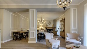 A spacious living room with a dining area, a chandelier, and a fireplace. - AMORE RENTALS - Villa Barbara with Private Pool and Garden (Palazzuolo sul Senio)